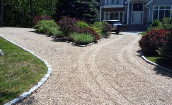 a driveway with gravel in front of a house