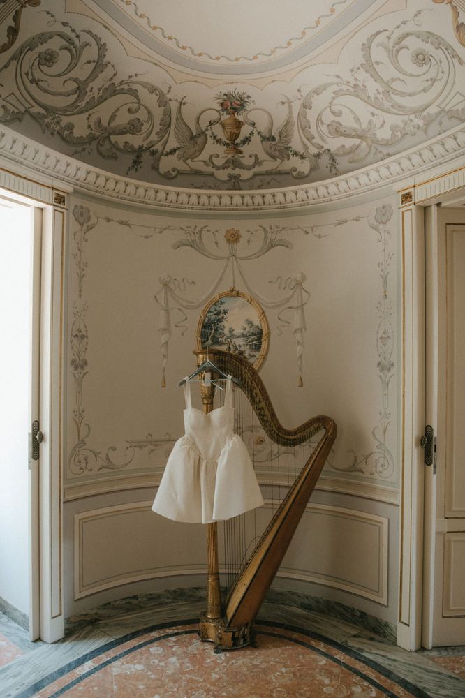 there is a harp in the corner of this room with a dress hanging on it