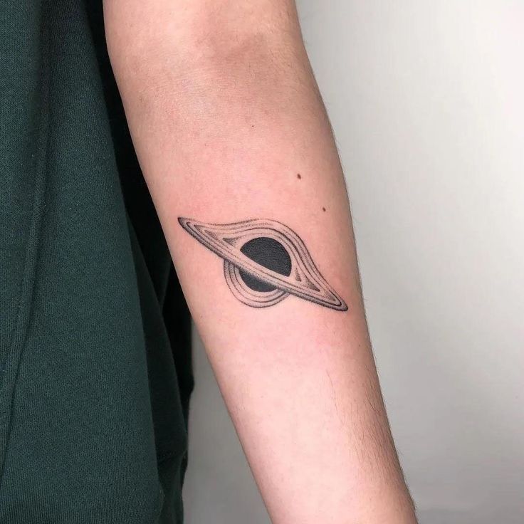 a man's arm with a saturn tattoo on the left side of his arm