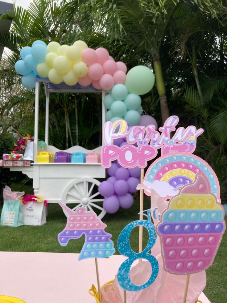 a birthday cake stand with balloons and decorations