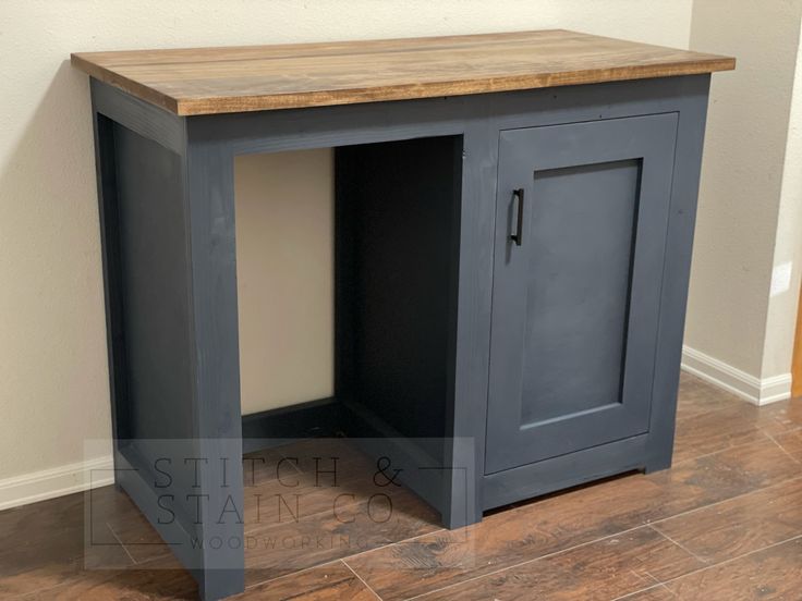 a small gray cabinet sitting on top of a hard wood floor next to a wall