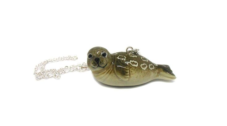 Ringed Seal Necklace This adorable ringed seal necklace would make the perfect gift for that special someone in your life that has a love of seals. This would make an awesome statement necklace! * Material: Ceramic * Size: 48 mm x 20 mm x 18 mm thick. You may pick from four different size chains, a 16, 18, 20 or 24 inch. All the chains are silver-finished brass, 2mm cable with a 1 inch extender. This silver-finished brass cable chain is long-lasting and has the look of precious metal without the Ceramic Seal, Ringed Seal, Pokemon Jewelry, Seal Jewelry, Seal Necklace, Tiger Jewelry, Grey Seal, Tiger Necklace, Necklace Ceramic