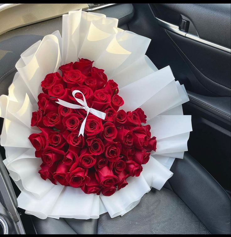 a bouquet of red roses in the back seat of a car