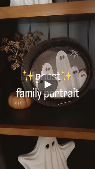 the ghost family portrait is sitting on top of a book shelf next to a pumpkin