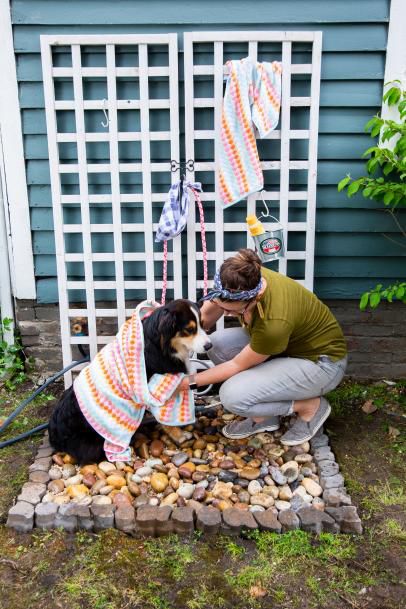 a woman kneeling down next to a dog with a towel on it's back