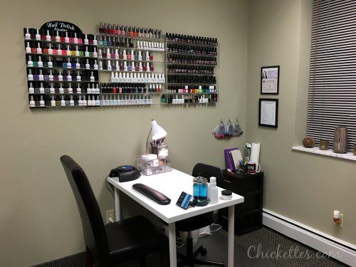 the salon has many bottles of nail polish on the wall