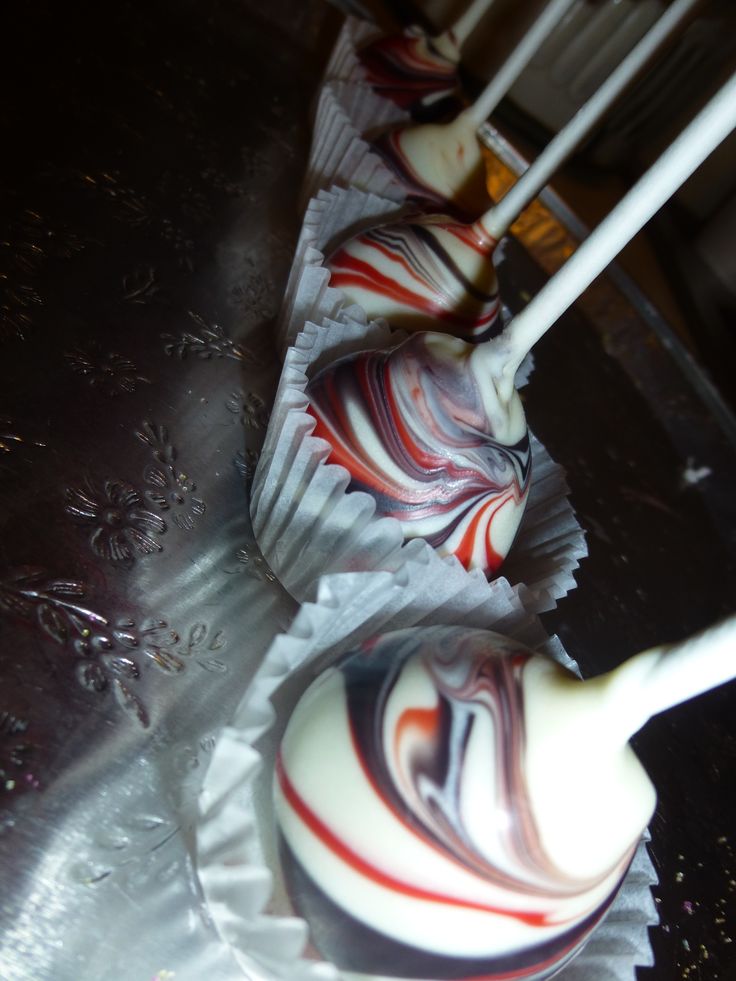 two chocolate lollipops sitting on top of each other with white sticks sticking out of them