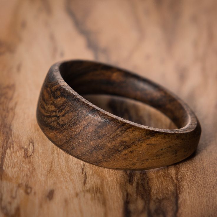 two wooden rings sitting on top of a wooden table with wood grained in to it