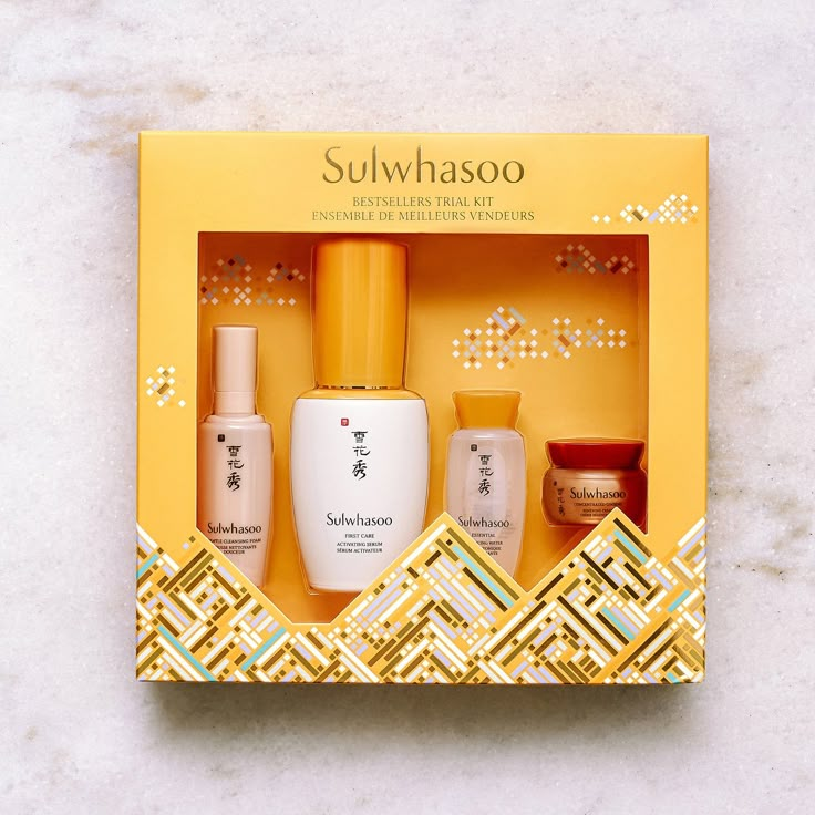 an open box containing some skin care products on a white surface with gold trimmings