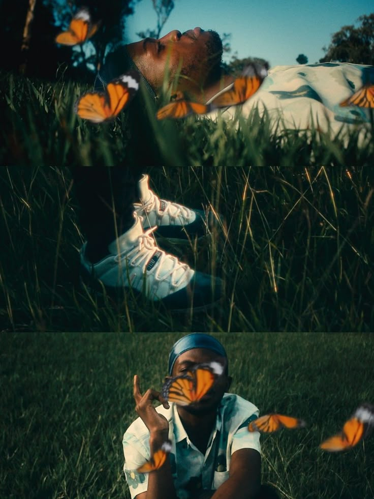 a man sitting in the grass with orange butterflies flying around him and looking up at his face