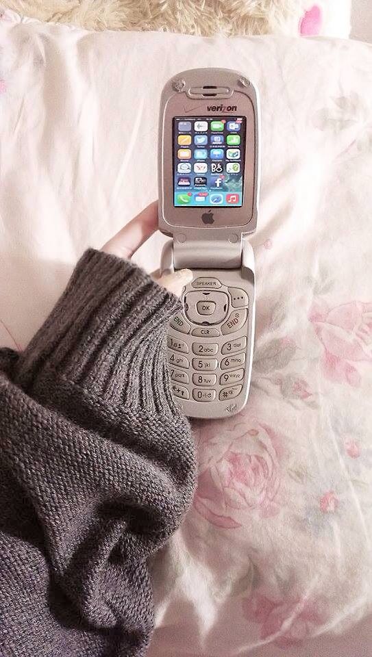 a cell phone sitting on top of a bed next to a pair of socks