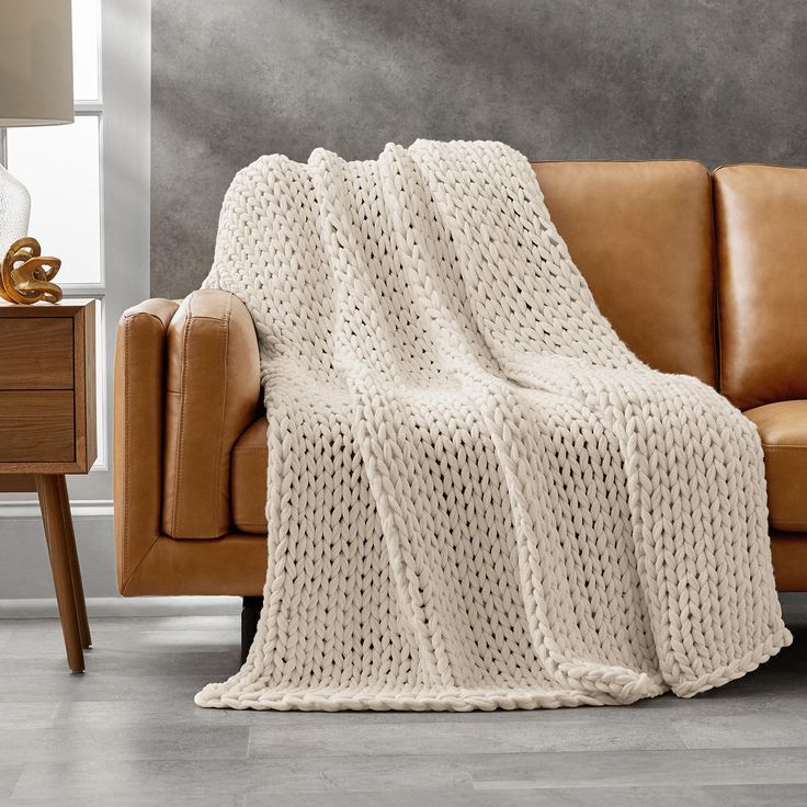 a couch with a white knitted blanket on it