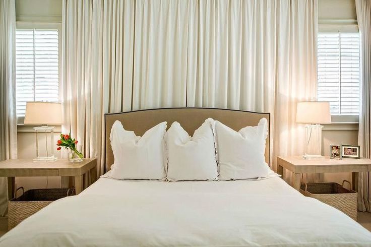 a bed with white sheets and pillows in a bedroom next to two lamps on either side of the bed