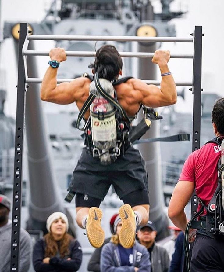 a man on a pull up bar in front of a crowd