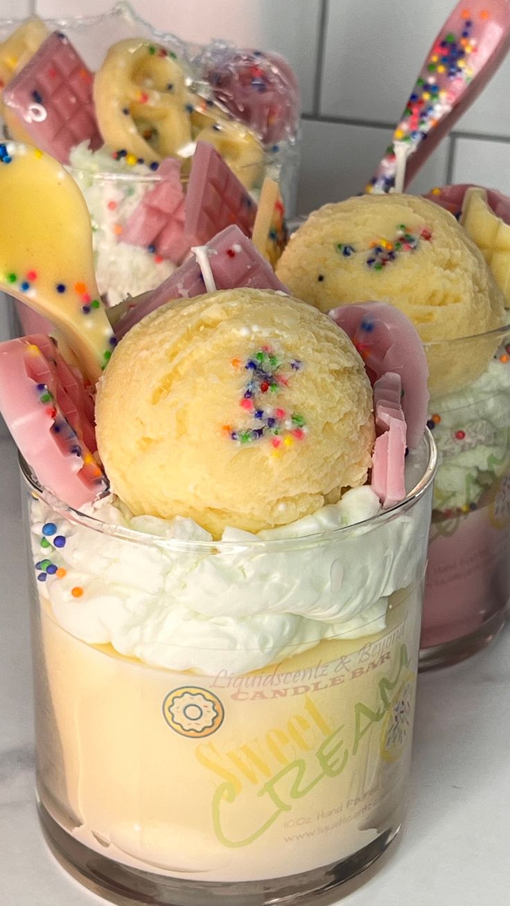 some cupcakes are sitting in a glass with ice cream and sprinkles