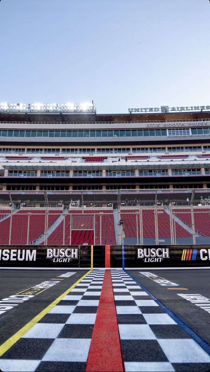 an empty stadium with red seats and checkered flooring on the side walk area