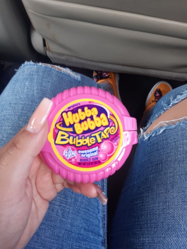 a person holding a pink bubble tart in their lap with the seat back open