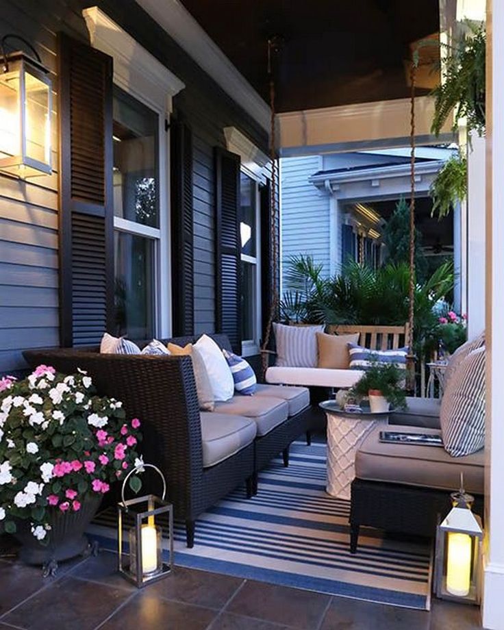 a porch with lots of furniture and flowers on it