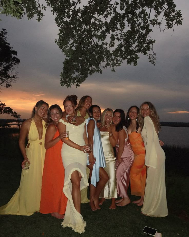 a group of women standing next to each other on top of a lush green field