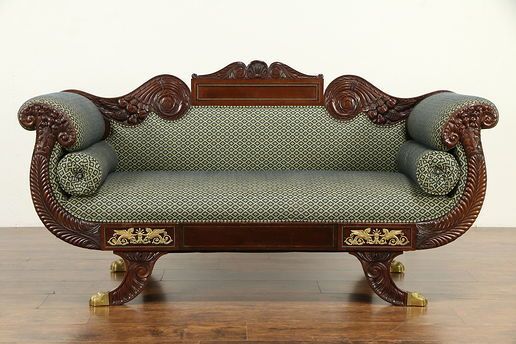 an ornate wooden couch sitting on top of a hard wood floor