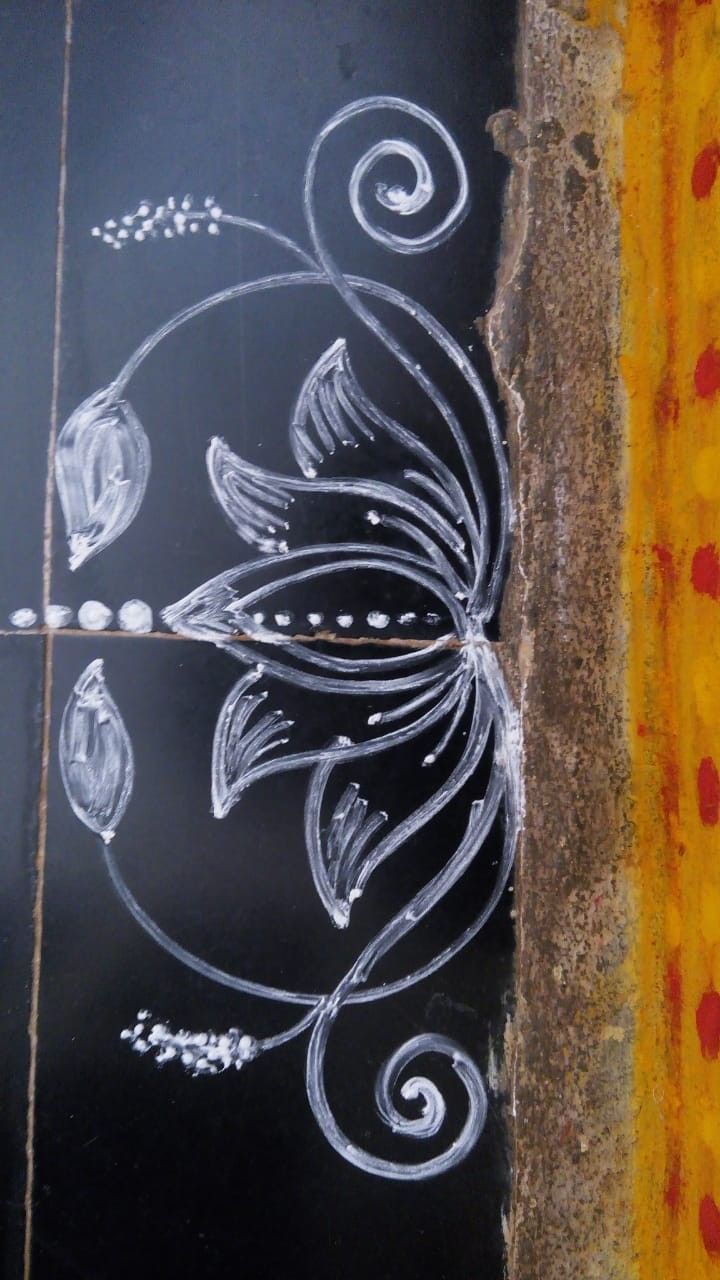 a chalk drawing on the side of a building with flowers and leaves painted on it