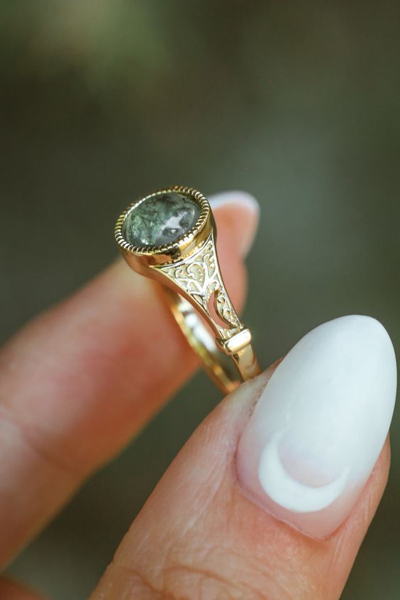 Product Details Ring Style: The "Selene" is an accented-style moss agate women's engagement ring. Many other center stone options are available upon request. Center Stone: 7mm Round Cut Moss Agate Materials: 14K gold engagement ring featuring a moss agate center stone Customizable: Because each ring is handcrafted to order, we can customize yours using unique materials, gemstones, or design features, often without any added cost! We can even use personal materials that you send! Basic ... Moss Agate Engagement Ring, Cute Engagement Rings, Future Engagement Rings, Agate Engagement Ring, Dream Engagement Rings, Funky Jewelry, Jewelry Lookbook, Stone Engagement Rings, Agate Ring