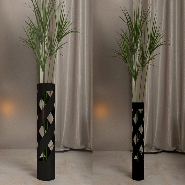 three tall black vases with plants in them