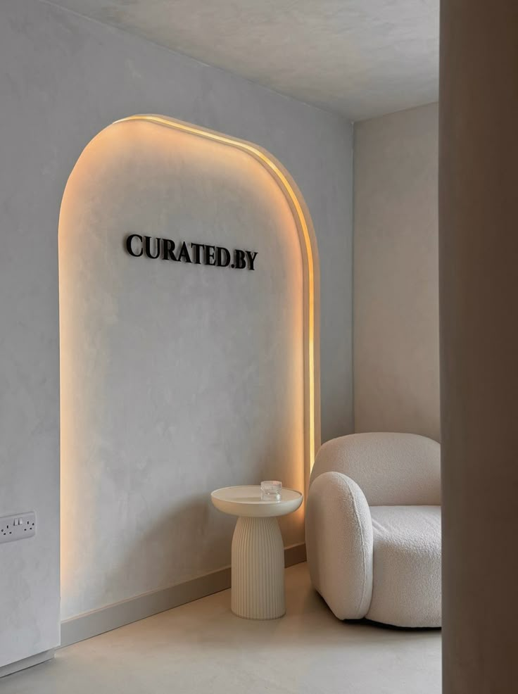 a room with a chair, table and sign on the wall that says curatbedy