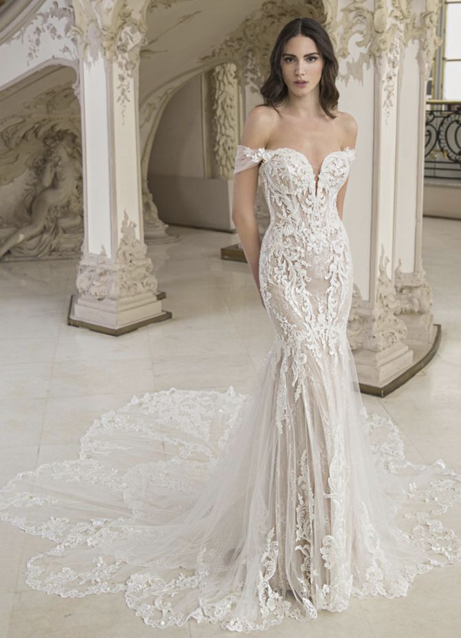 a woman in a white wedding dress standing on a marble floor next to an ornate staircase