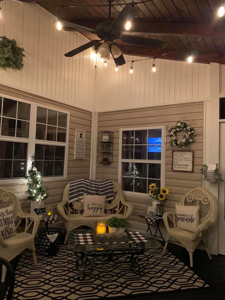 a living room with wicker furniture and lights on the ceiling is lit by string lights