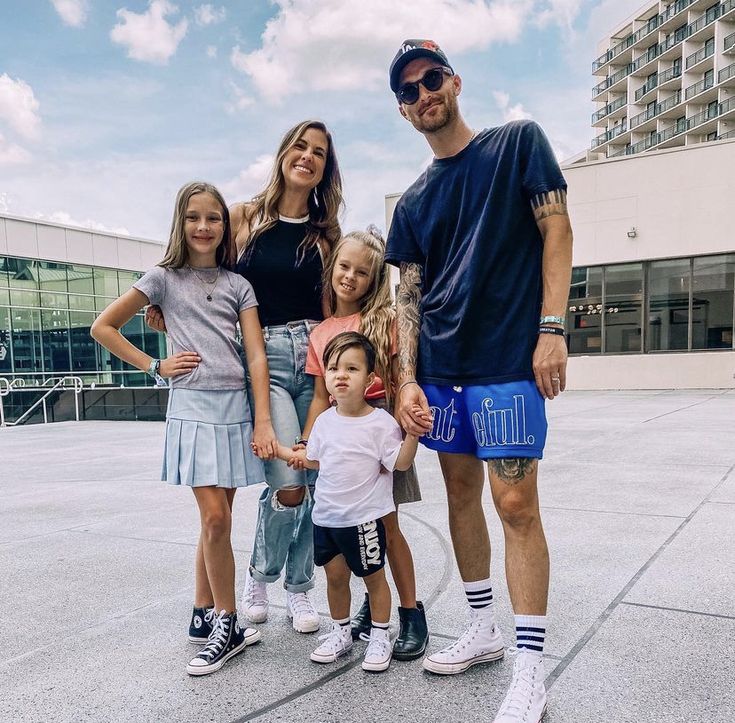 a family poses for a photo in front of a building with the sky behind them