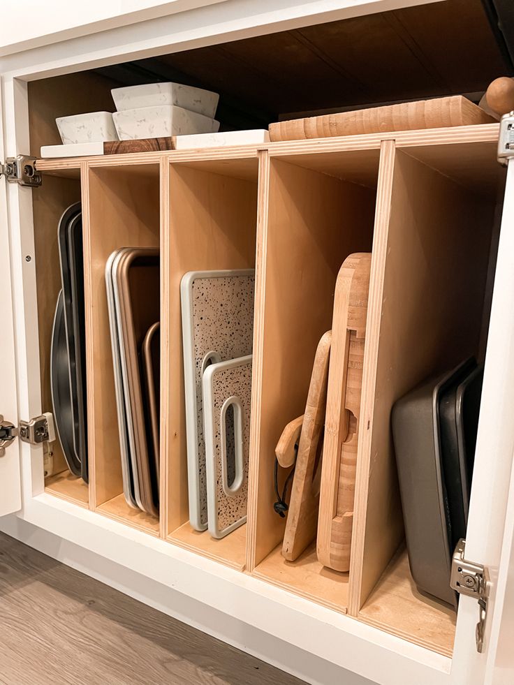 an open cabinet filled with different types of kitchen utensils