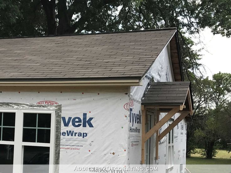 a house under construction with the roof ripped off and windows taped down to it's sides