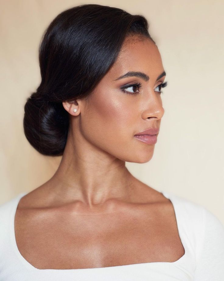 a woman with dark hair wearing a white top and looking off to the side, in profile