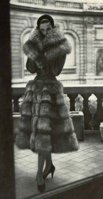 a woman in a long fur coat and heels