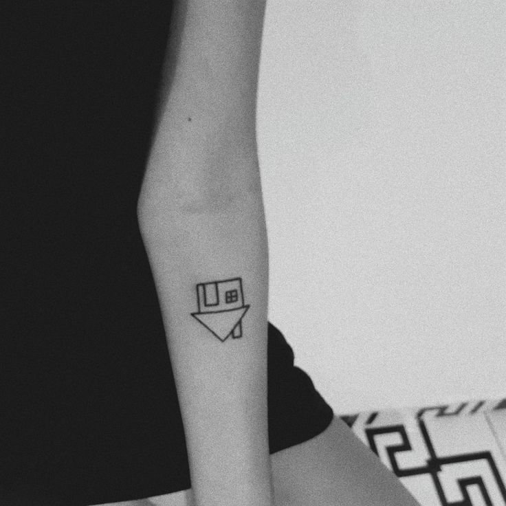 a black and white photo of a woman's arm with an envelope tattoo on it