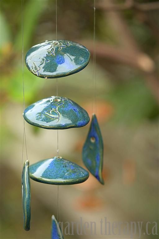 a wind chime with blue and white designs hanging from it