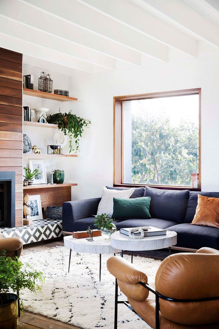 a living room filled with furniture and a fire place in front of a large window