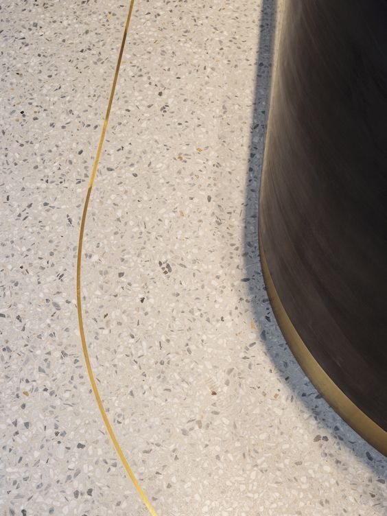 a black and white cat laying on the floor next to a yellow cord that has been attached to it