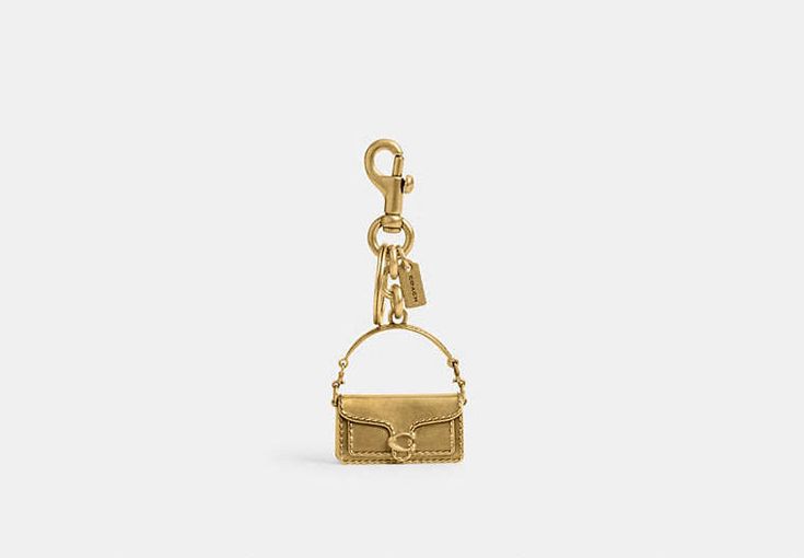 Rectangular Logo Bag Charm, Rectangular Bag Charm With Key Clip, Elegant Everyday Bag Charm With Logo, Gold Bags With Logo Charm, Gold Rectangular Keychain With Key Leash, Luxury Keychain With Key Clip For Gift, Luxury Keychain With Key Clip As Gift, Rectangular Key Leash Bag Charm For Everyday, Rectangular Keychain With Key Leash For Daily Use