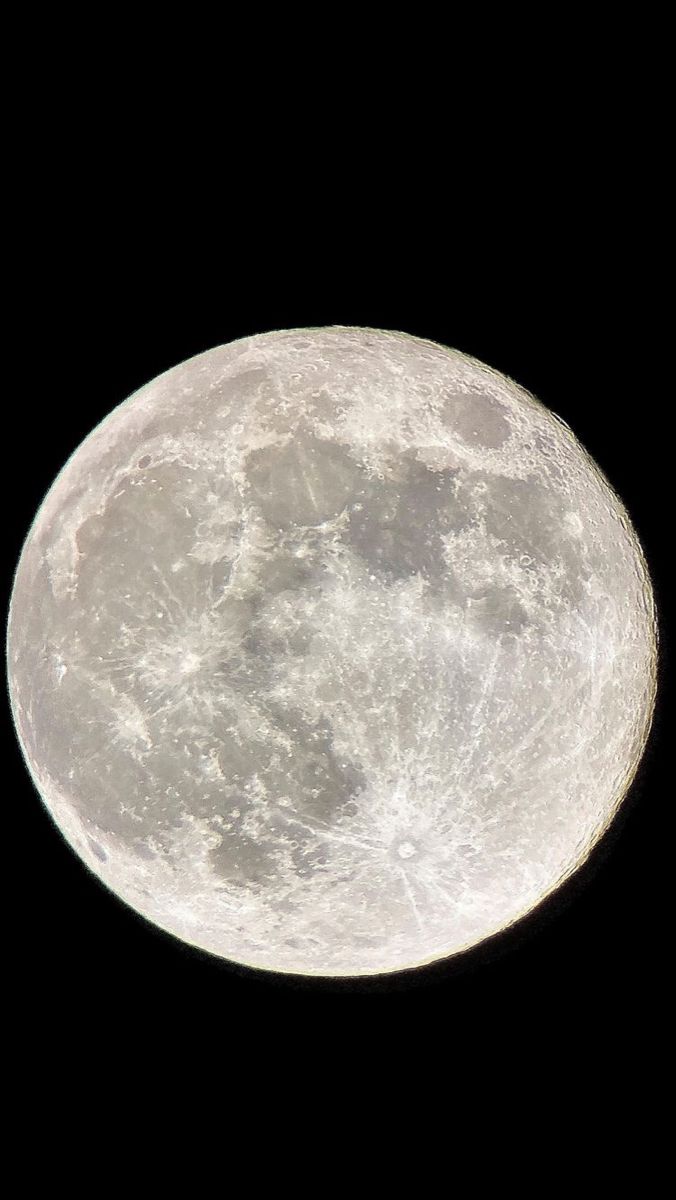 an airplane flying in the sky with a full moon behind it's back end