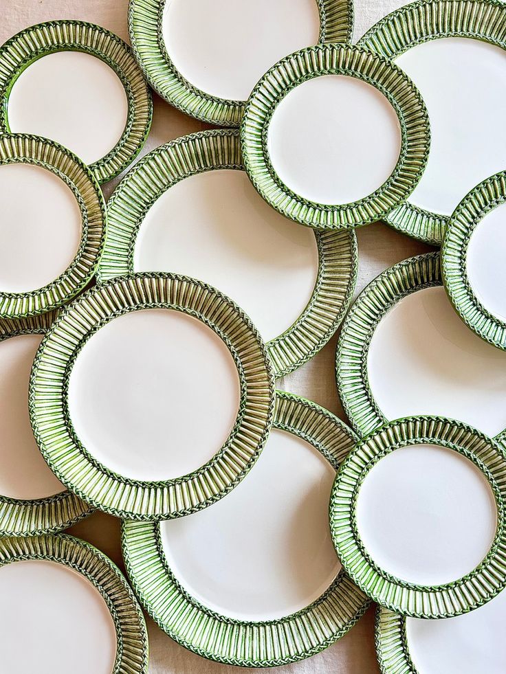 many green and white plates stacked on top of each other in the shape of circles