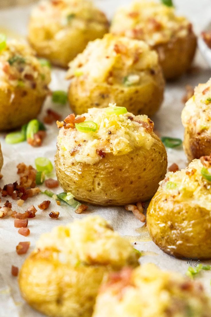 baked potatoes with bacon and green onions on a sheet of parchment paper, ready to be eaten