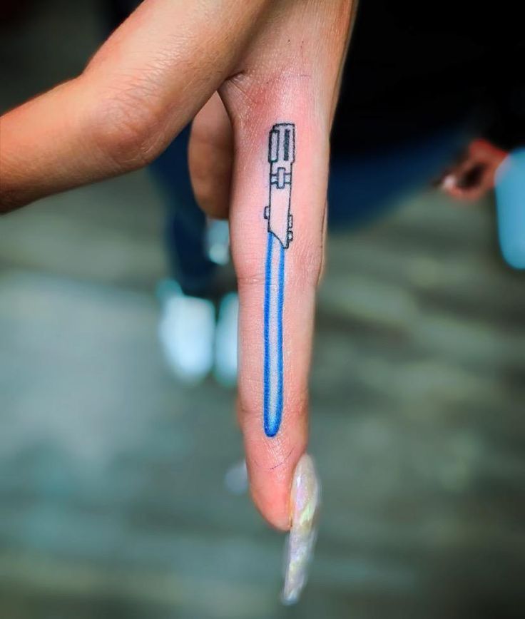 a person's finger with a blue pen tattoo on it