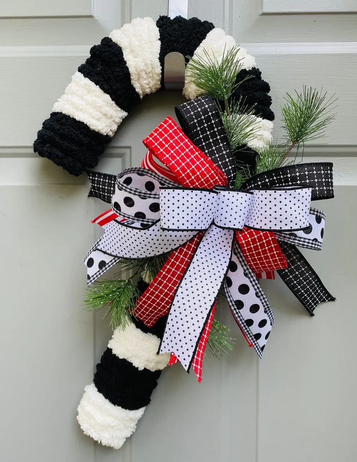 a christmas wreath with black, white and red bows