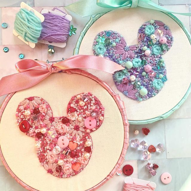 two cross stitch mouses are on the table next to some buttons and other crafting supplies