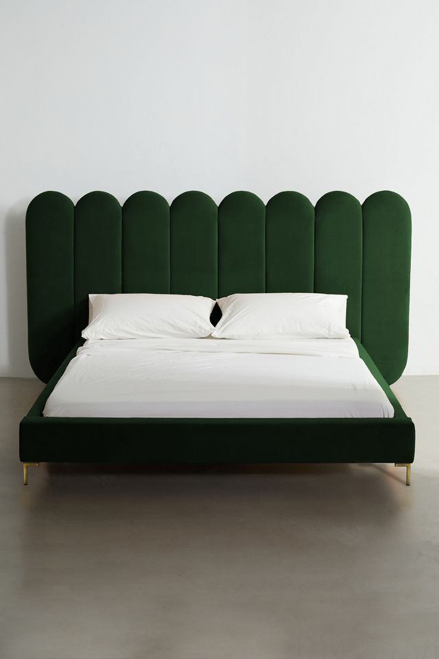 a bed with a green headboard and white sheets