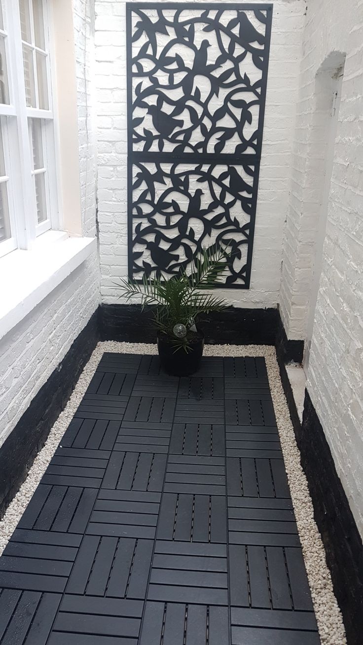 a black and white tile floor in front of a window with potted plant on it