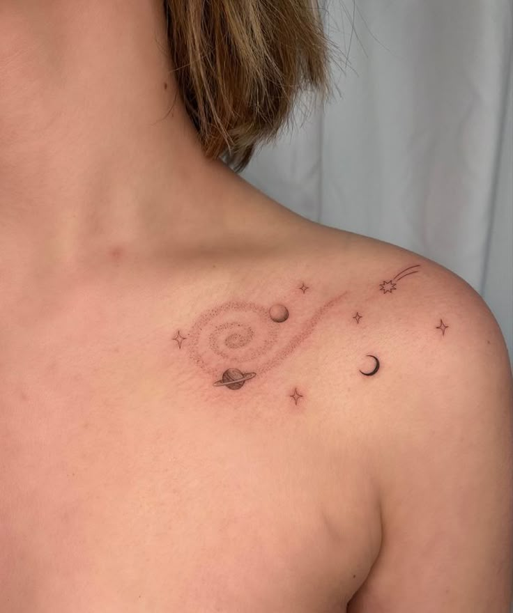 a woman's chest with stars and planets in the sky on her left side