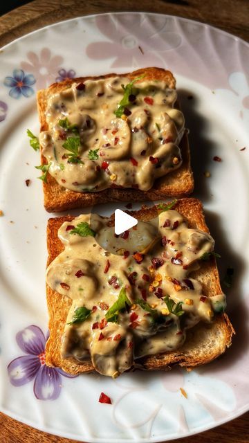 two pieces of bread topped with melted cheese and herbs on a flowered paper plate